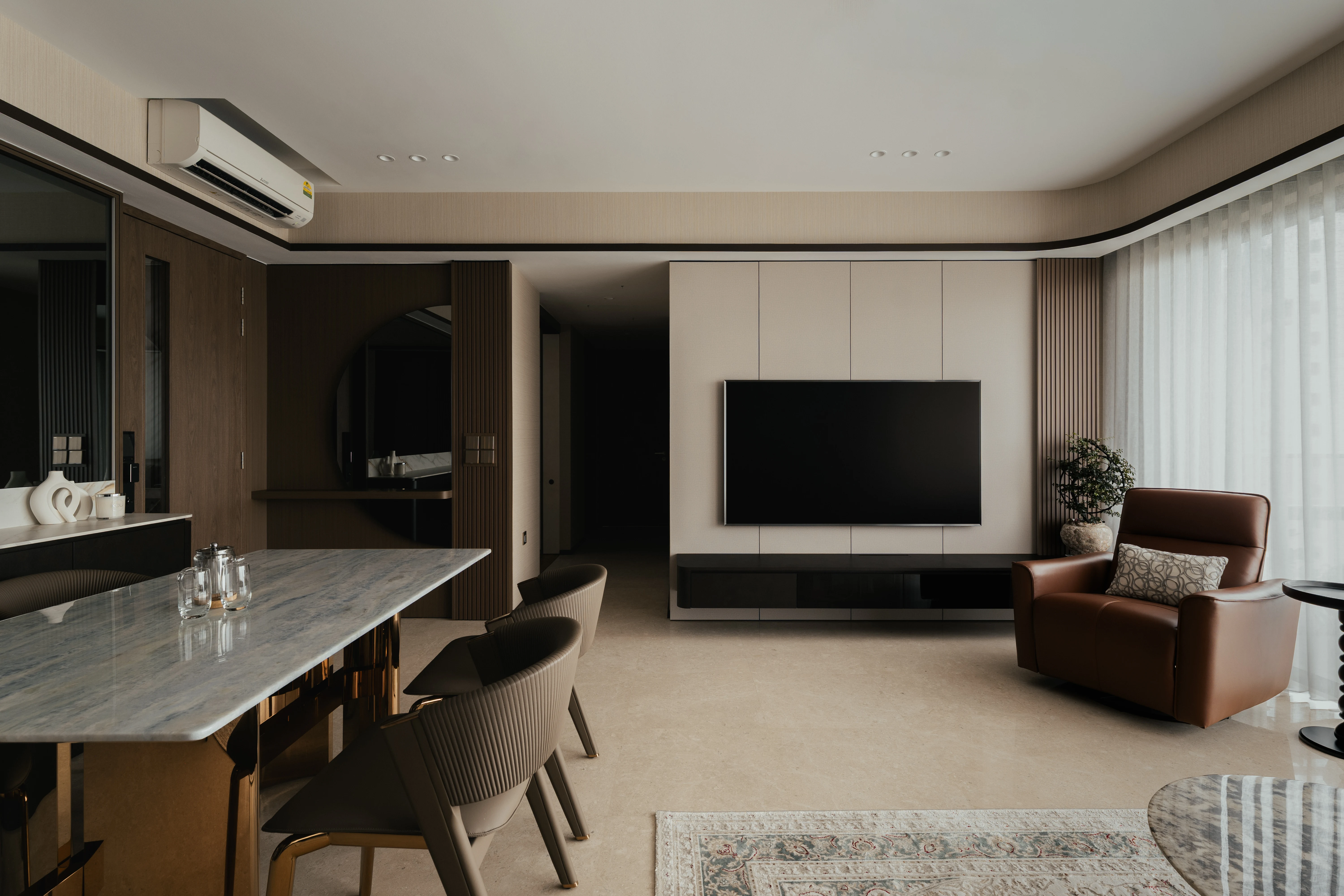 Clavon — dining and living area with marble table and cream TV feature wall