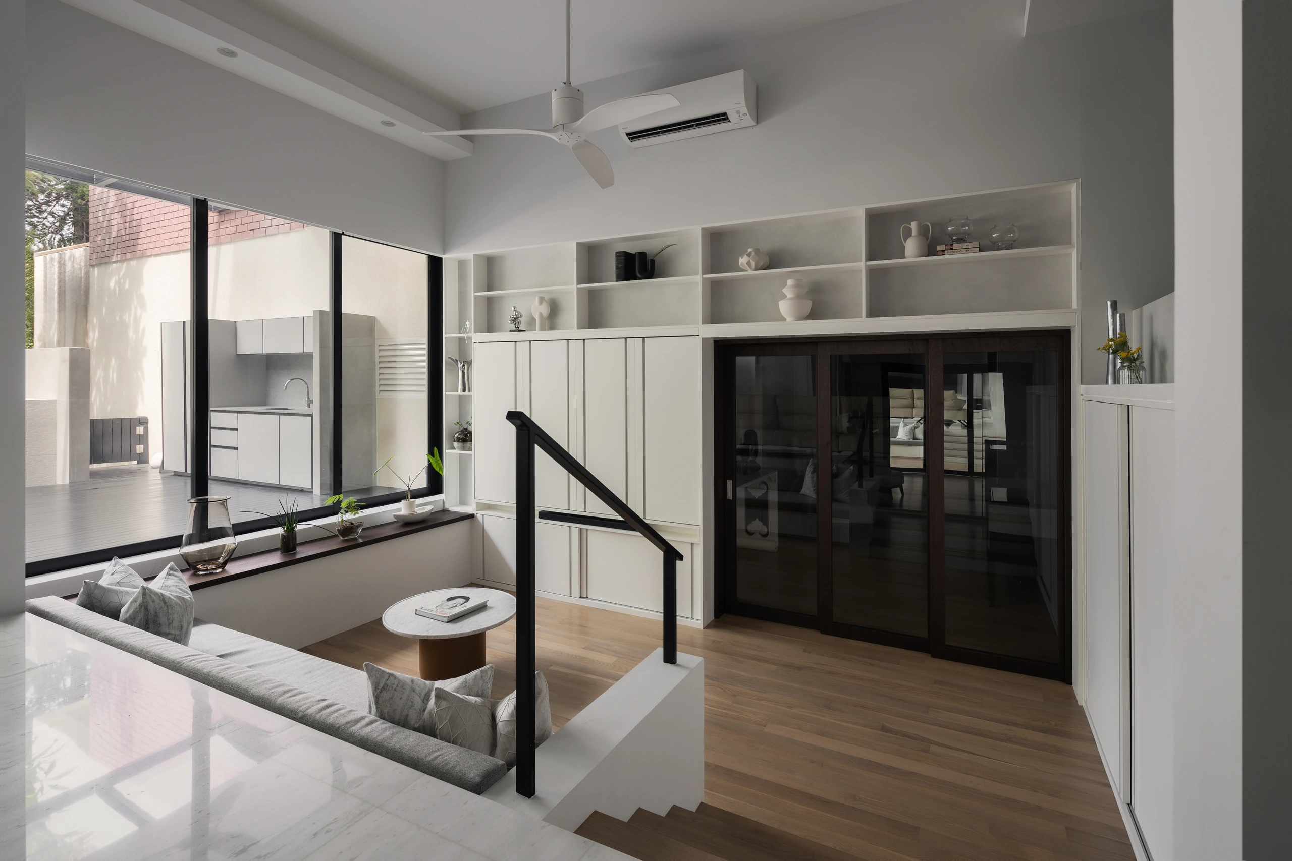 Sunken lounge beside full-height garden windows by Edgeline Planners