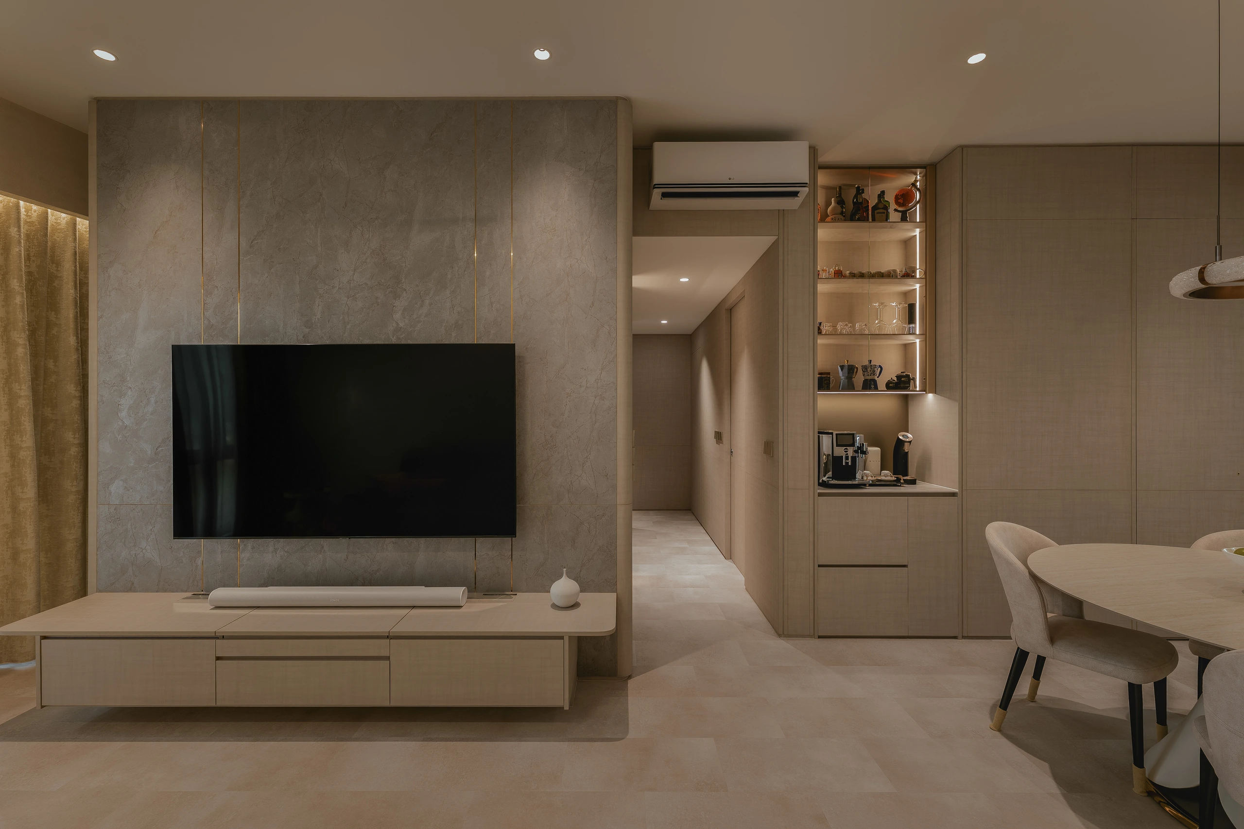 Open living and dining room with illuminated coffee niche by Edgeline Planners