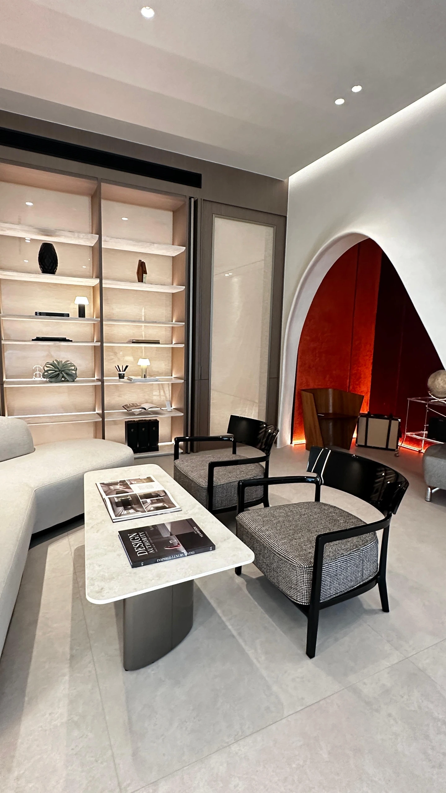 Living room with illuminated shelving and red-lined arch by Edgeline Planners