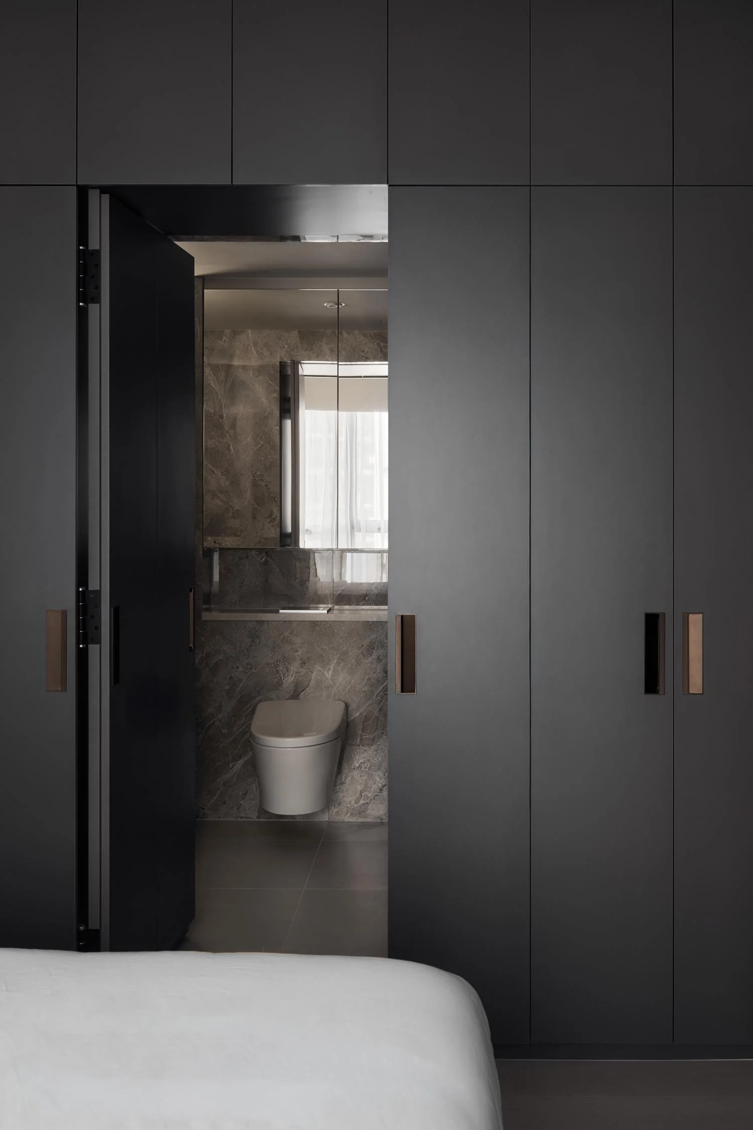 Concealed bathroom entrance integrated with master bedroom wardrobe