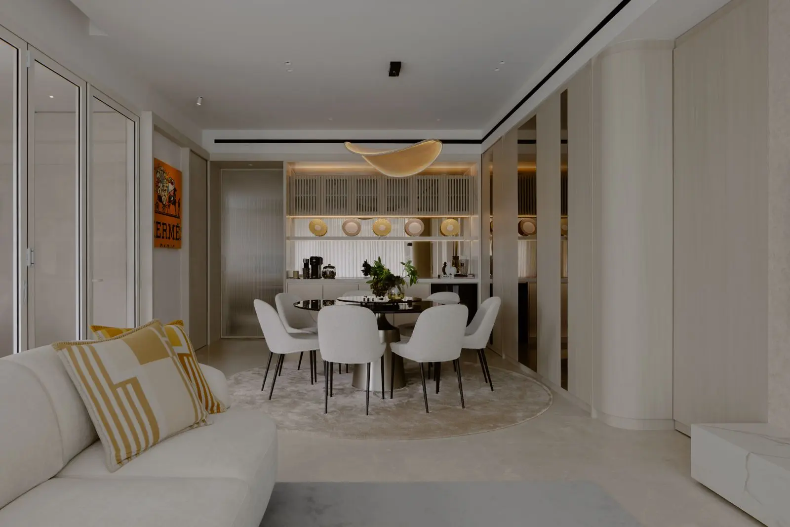 Living and dining room by Uncommon Studio with concealed storage and warm neutral finishes